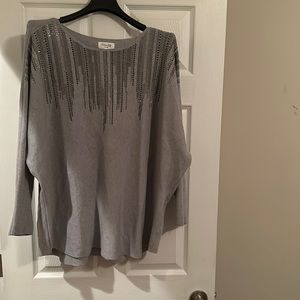 A gray pre-fall sweater embellished with silver and black rhinestones.